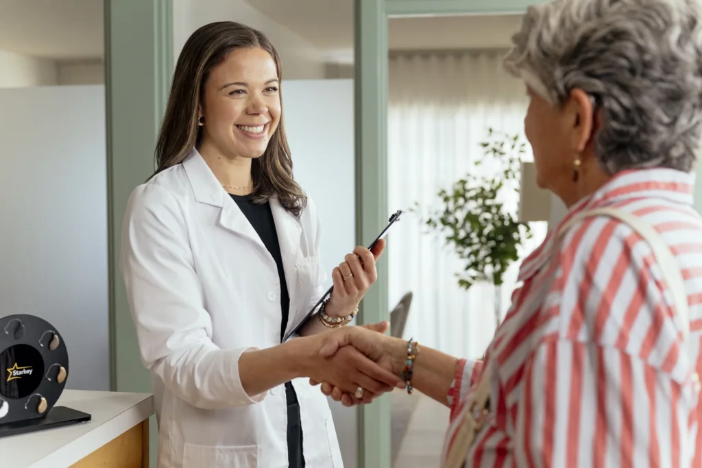 Hearing specialist helping patient at their first appointment after being fit for Aris AI